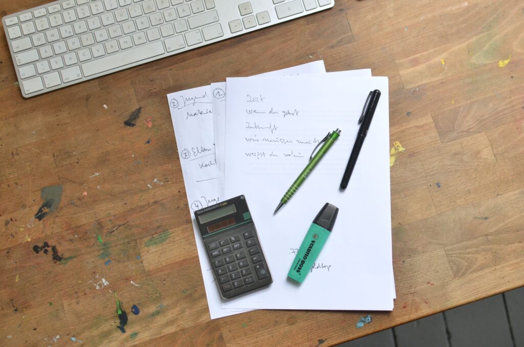 Calculadora y documentos sobre una mesa para calcular el IRPF de la venta de una vivienda