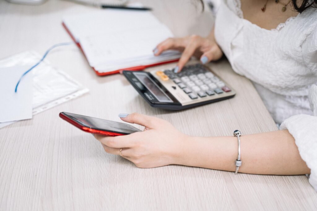 Persona calculando el IRPF por la venta de una vivienda con calculadora y documentos